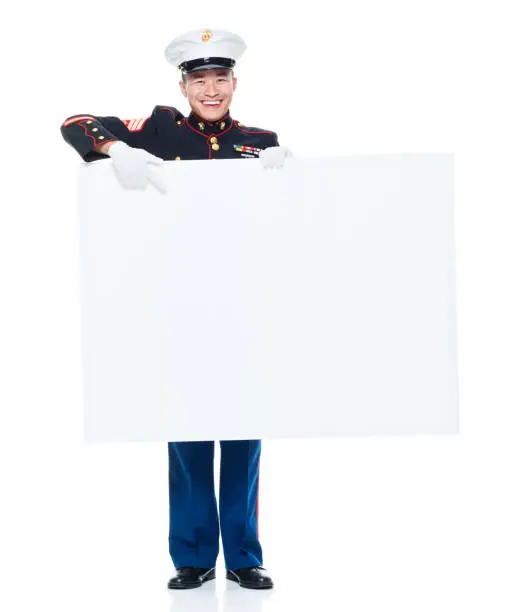 Photo of US Marine in uniform holding placard