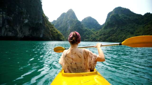 Young Caucasian woman  kayaking in Halong Bay