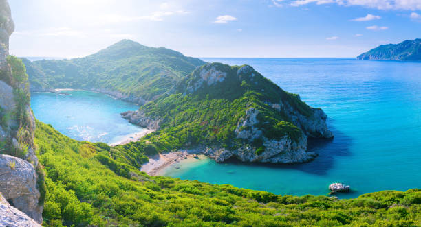 美しい夏のパノラマ風景。透明な紺碧の海に崖のビュー湾と遠くの島々。ユニークな静かなビーチ。アギオス ・ ステファノス岬。afionas。コルフ。ギリシャ。 - corfu greece sea beach ストックフォトと画像