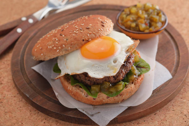 Hamburger with fried egg and gherkin salad