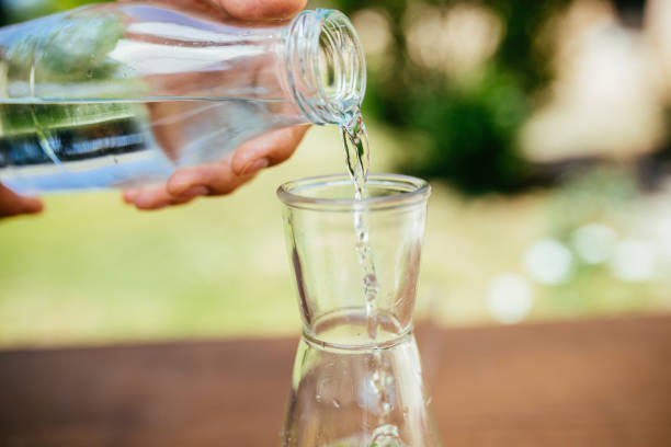 istock Pouring Water In The Bottle With Cucumber 951345690