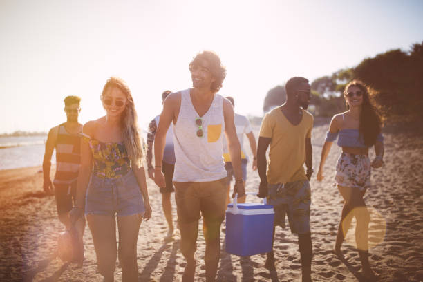 istock Young multi-ethnic hipster friends with cooler box on the beach 951349104