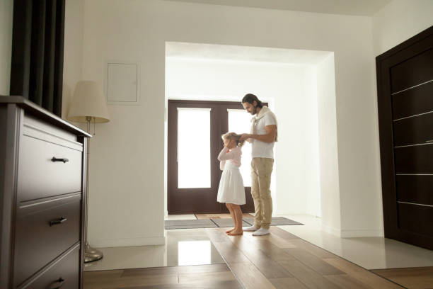 istock Caring father braiding daughters hair standing in hall before leaving 951349592