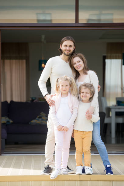 istock Parents and children looking at camera standing on house terrace 951349906