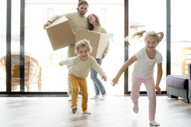 Funny happy kids running into new house on moving day Funny happy kids running into new house on moving day, excited children boy and girl play inside luxury big modern room while smiling parents entering own home, family mortgage and relocation concept hello stock pictures, royalty-free photos & images