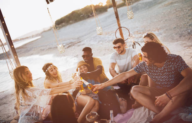 istock Young multi-ethnic friends toasting with beer at summer beach party 951356020