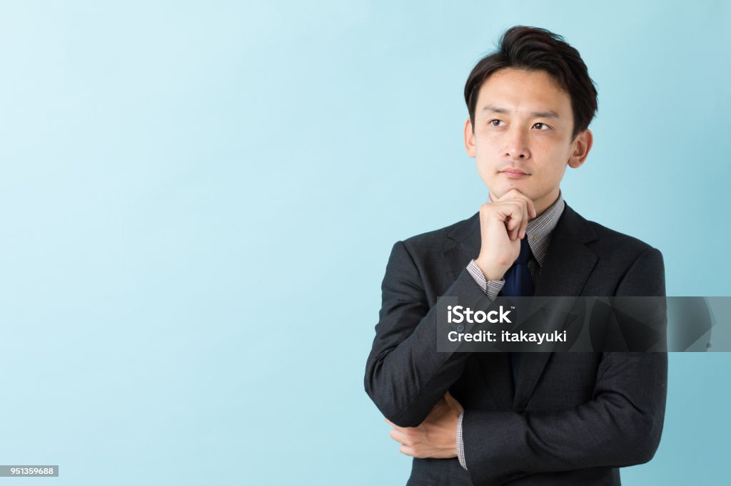 portrait of asian businessman isolated on blue background Worried Stock Photo