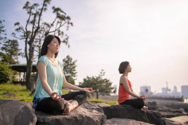 istock Two women practicing yoga on rock 951367134