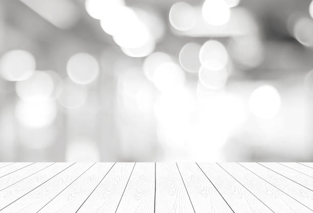 istock Empty vintage white wood table over blur store background, perspective wooden board background for product and food display montage 951378378