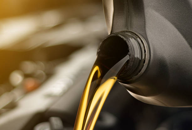 verter aceite lubricante coche de motor de botella negra sobre fondo blanco aislada - gasoline motor fotografías e imágenes de stock