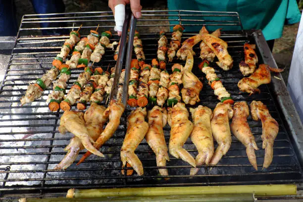 Barbecued food at Ho Chi Minh city, Vietnam, grill chicken wings on grilled, popular snack street food from white meat but unhealthy
