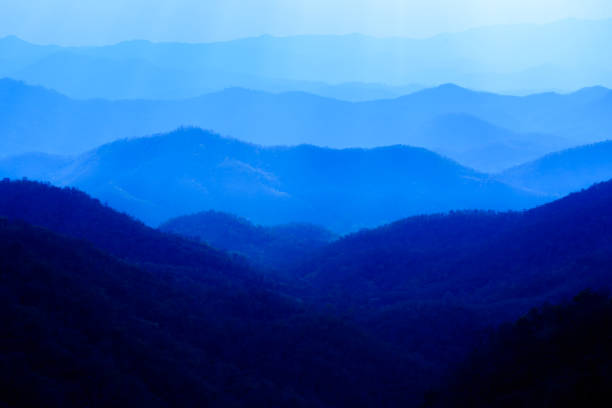 istock Beautiful landscape of blue mountains layers during sunset with sunrays 951392188