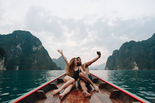 Pareja tomando selfie en un barco de cola larga photo