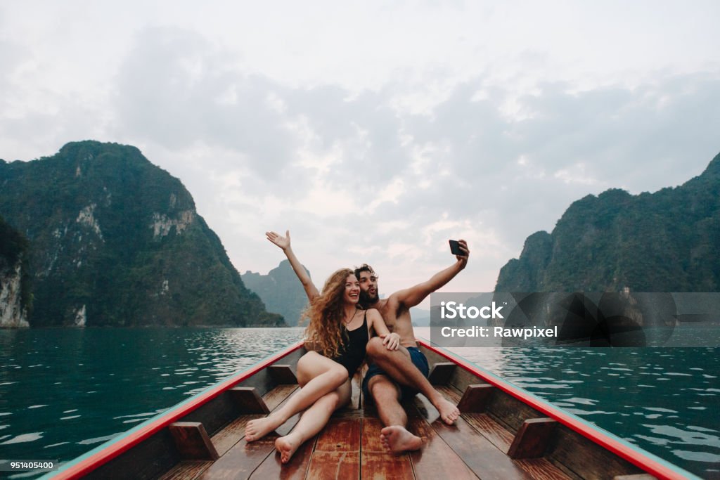 Coppia che si fa selfie su una barca longtail - Foto stock royalty-free di Viaggio