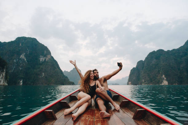 coppia che si fa selfie su una barca longtail - romance honeymoon couple vacations foto e immagini stock