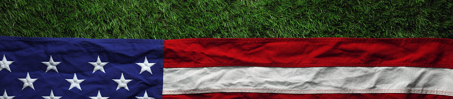 Red, white, and blue American flag on grass for Memorial Day or Veteran's day background