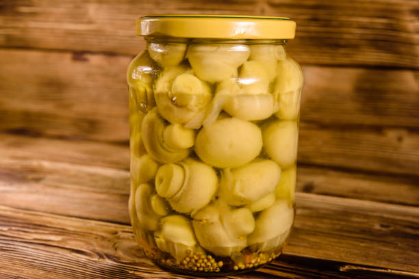 istock Jar with canned mushrooms on wooden table 951408178