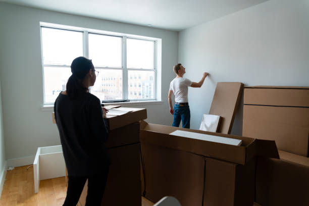 the family moving in to the new apartment. the young 30 years old man and teenager girl unboxing and assembling furniture. - independence lifestyles smiling years imagens e fotografias de stock