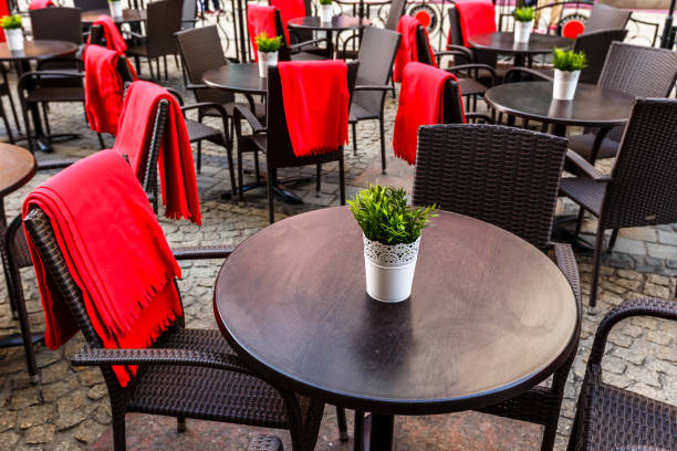 istock Empty tables and wicker chairs on paving stones in a cafe in old town. 951427198