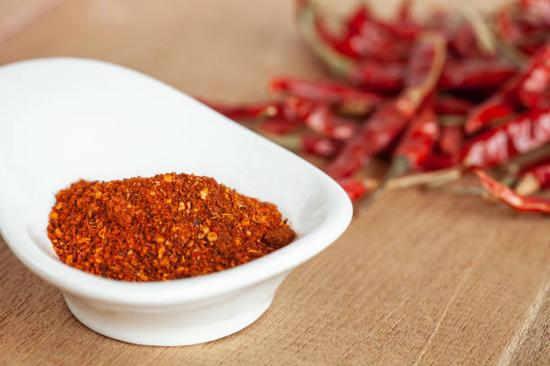 istock Cayenne pepper in white dish and dried chilli on wood table. 951430678