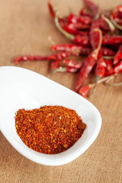 istock Cayenne pepper in white dish and dried chilli on wood table. 951430696