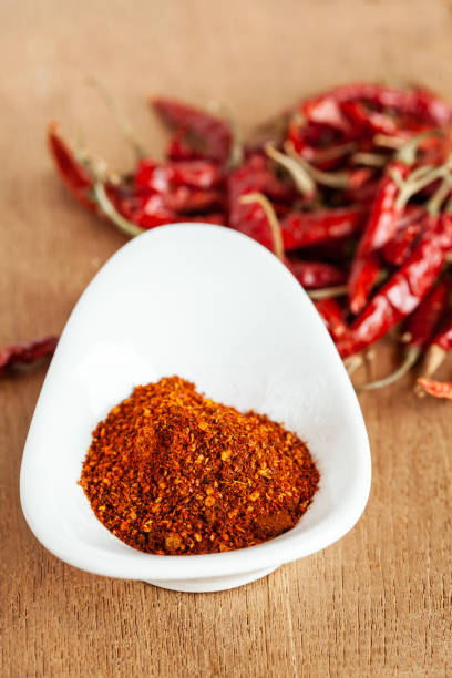 istock Cayenne pepper in white dish and dried chilli on wood table. 951430700