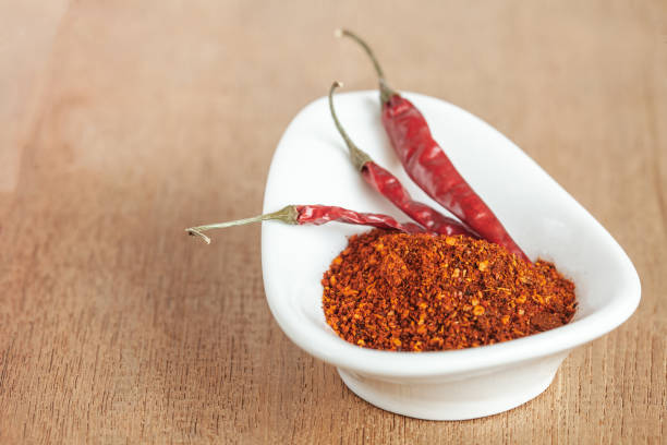 istock Cayenne pepper in white dish and dried chilli on wood table. 951430748