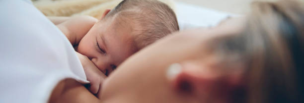 istock Newborn lying on the bed with her mother 951435490