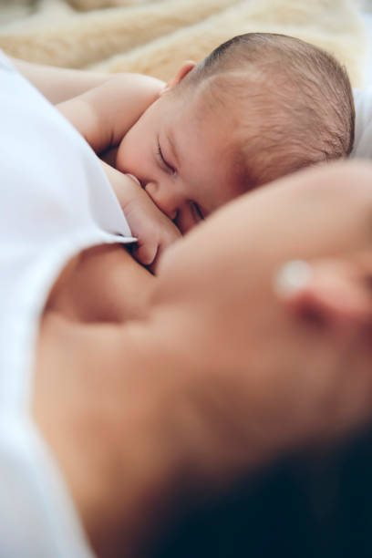istock Newborn lying on the bed with her mother 951435514