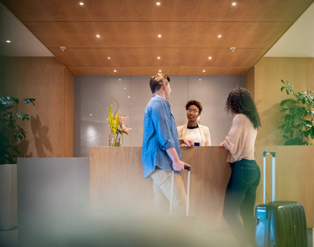 couple talking to receptionist at hotel lobby - hotel reception imagens e fotografias de stock