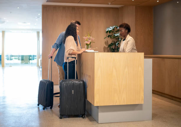 istock Business travellers discussing with receptionist at hotel lobby 951447278