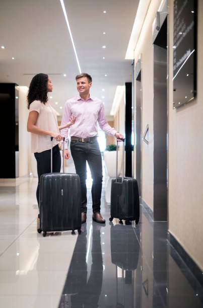 istock Couple with luggage talking in hotel corridor 951447830