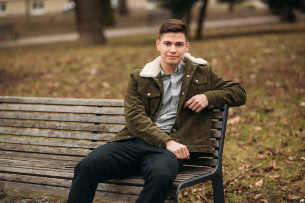istock Nice guy sitting on the bench outdoors in cloudy weather 951451492