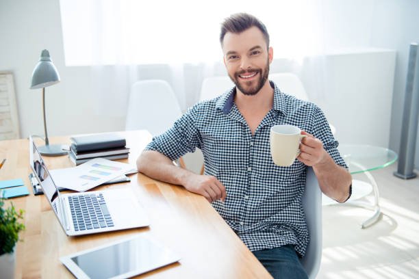 istock happy young businessman having break and drink coffee at workplace 951451540