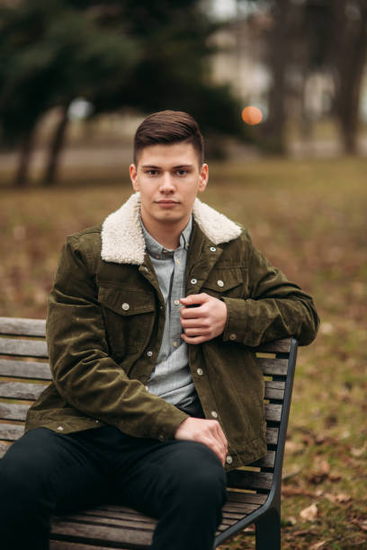 istock Nice guy sitting on the bench outdoors in cloudy weather 951451584