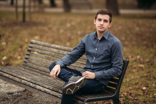 istock Nice guy sitting on the bench outdoors in cloudy weather 951451652