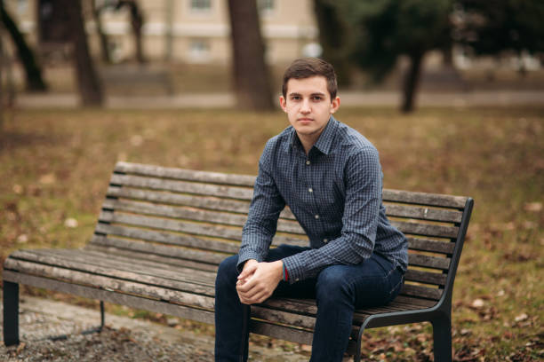 istock Nice guy sitting on the bench outdoors in cloudy weather 951451690