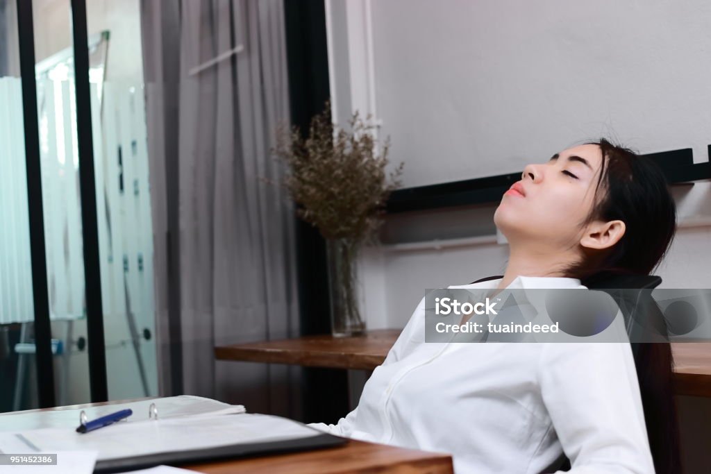 アジア ビジネスの女性は、事務所の職場で仕事から疲れて過労若いを強調しました。 - 1人のロイヤリティフリーストックフォト