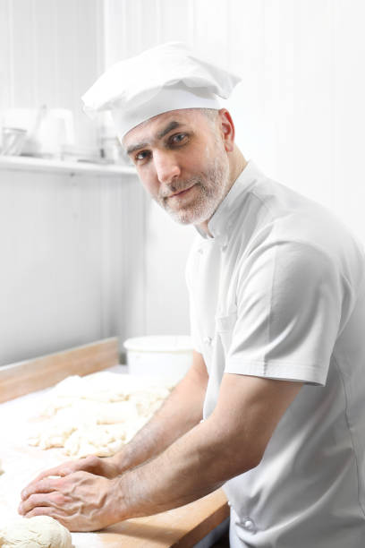 istock Pizza dough. The man kneads the dough. 951455832