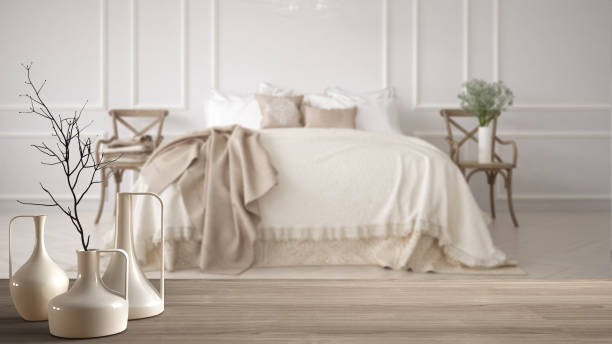 istock Wooden table top or shelf with minimalistic modern vases over blurred minimalistic classic bedroom, white interior design 951456498