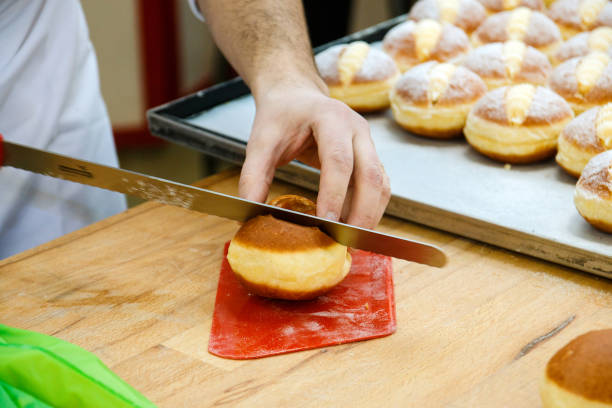 istock pastry chef cuts a bun with a knife to fill it with cream 951462056