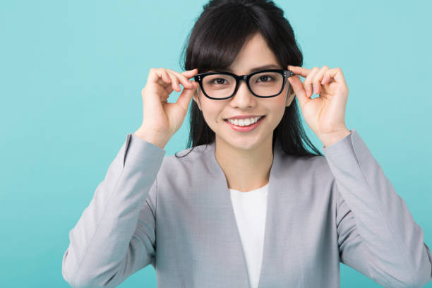 istock A woman in suit smiles touching glasses 951470728