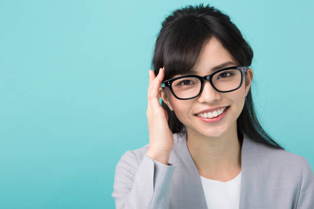 istock A woman in suit smiles touching glasses 951470732