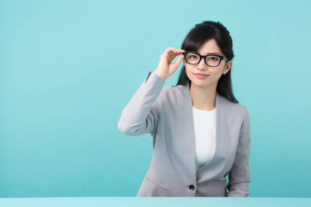 istock A woman in suit smiles touching glasses 951470738