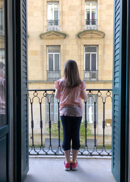 istock Little girl looking through window 951470990