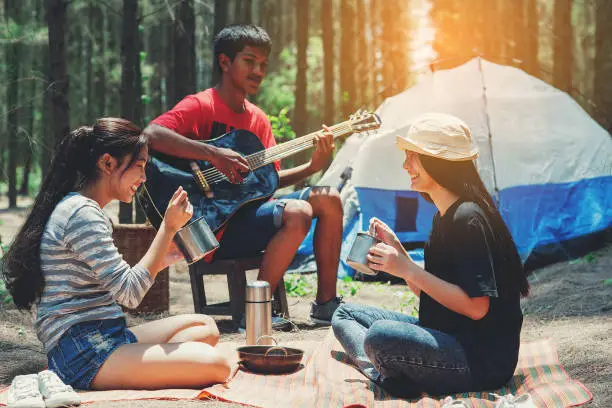 Asian teenager group to  picnic and enjoy guitar to travel in nature,Travel and Recreation Concept