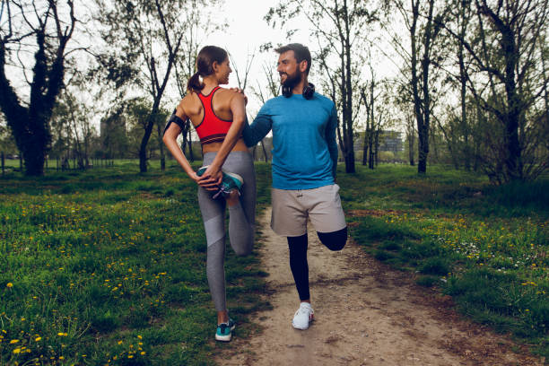 istock Fit athlete couple doing stretching exercises on running track 951477196