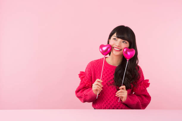 istock A woman in red sweater holding hearts 951477818