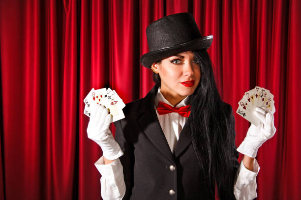 Magician holding a playing cards Beautiful young magician holding a playing cards female magician stock pictures, royalty-free photos & images