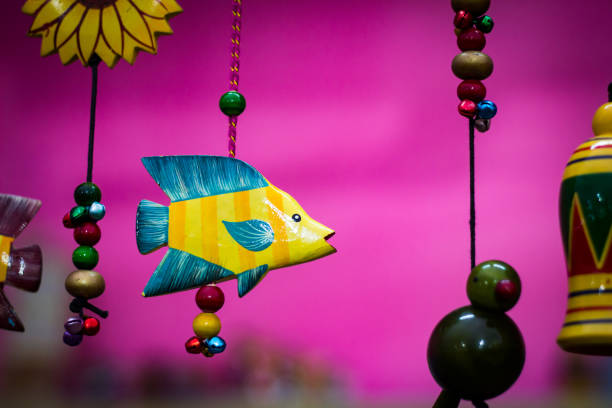istock yellow wooden fish with blue fins suspended by beaded string 951480796